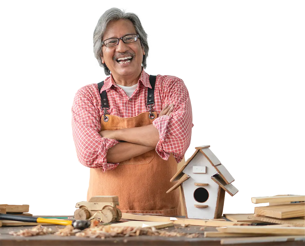 A man smiling in front of a birdhouse he built